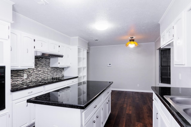 kitchen with a kitchen island, white cabinetry, decorative backsplash, dark wood-type flooring, and a textured ceiling