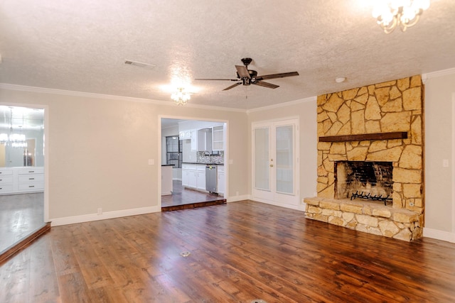 unfurnished living room with crown molding, hardwood / wood-style floors, a fireplace, a textured ceiling, and ceiling fan with notable chandelier