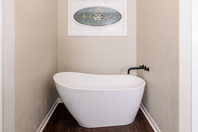 bathroom with hardwood / wood-style floors and a washtub