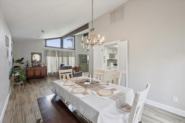 5955 Bicentennial Ln, Beaumont, TX 77706 - dining area with a chandelier, wood finished floors, and high vaulted ceiling