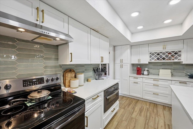 5955 Bicentennial Ln, Beaumont, TX 77706 - kitchen featuring stainless steel electric range, decorative backsplash, under cabinet range hood, light countertops, and white cabinets