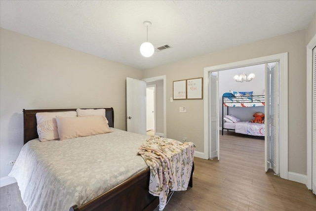 5955 Bicentennial Ln, Beaumont, TX 77706 - bedroom featuring wood finished floors and a chandelier