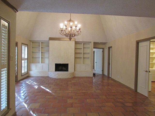 unfurnished living room featuring built in features, a textured ceiling, a brick fireplace, high vaulted ceiling, and a notable chandelier