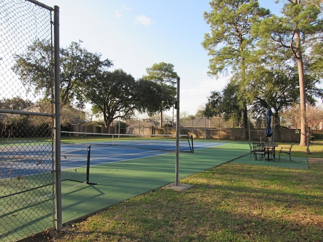 view of sport court featuring a yard and fence