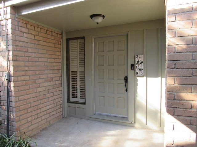 doorway to property with brick siding