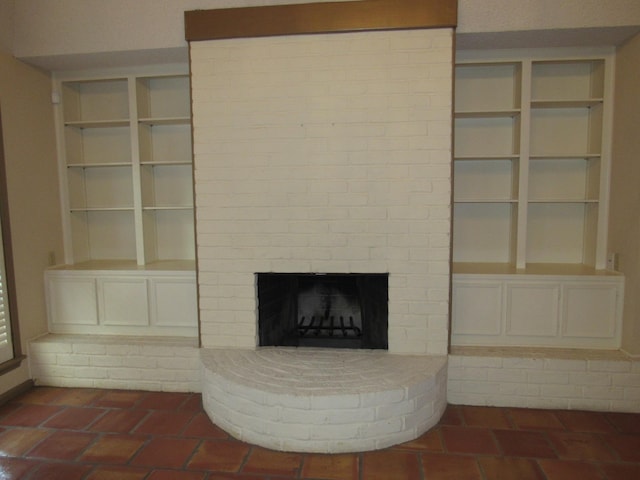 unfurnished living room with a brick fireplace and brick floor