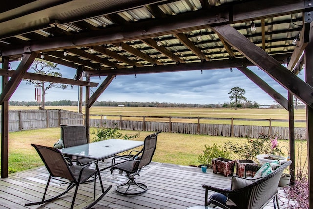 deck with a rural view, a lawn, and a pergola