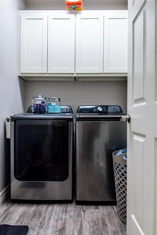 laundry area with light hardwood / wood-style flooring, cabinets, and independent washer and dryer