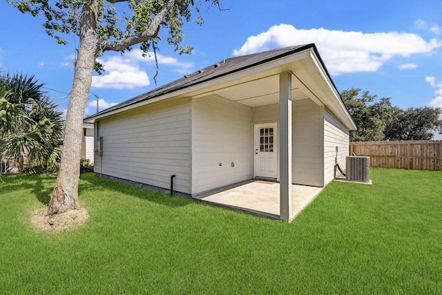 rear view of property featuring a patio, central AC unit, and a lawn