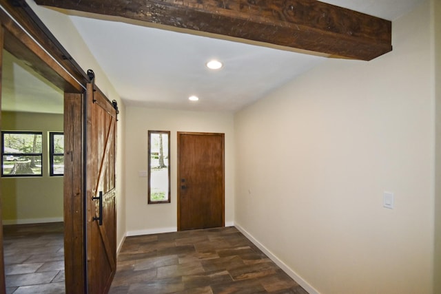 foyer entrance with a barn door, recessed lighting, and baseboards