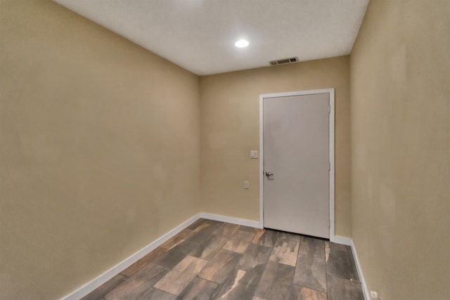 spare room featuring dark wood-style floors, baseboards, and visible vents