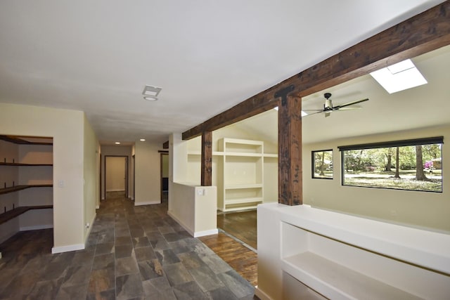 hall featuring dark wood-style floors, baseboards, a skylight, recessed lighting, and beamed ceiling