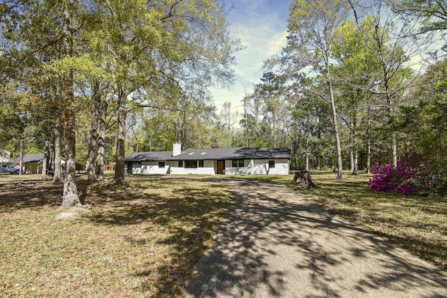 single story home with driveway and a chimney