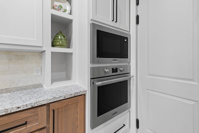 kitchen with oven, white cabinets, backsplash, built in microwave, and open shelves