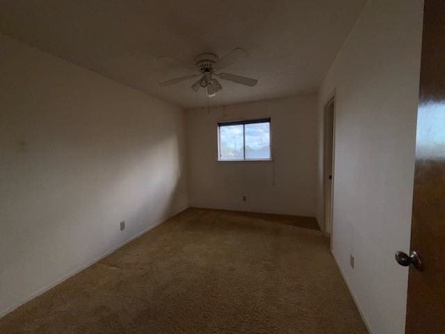 spare room with light colored carpet and ceiling fan