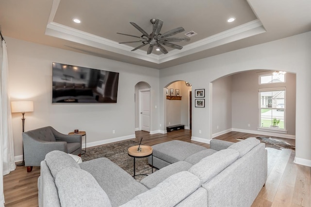 4813 Augusta Dr, Groves, TX 77619 - living room featuring arched walkways, a tray ceiling, a ceiling fan, wood finished floors, and recessed lighting