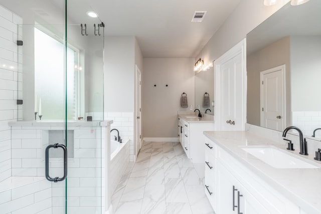 4813 Augusta Dr, Groves, TX 77619 - bathroom featuring marble finish flooring, two vanities, a bath, and a shower stall