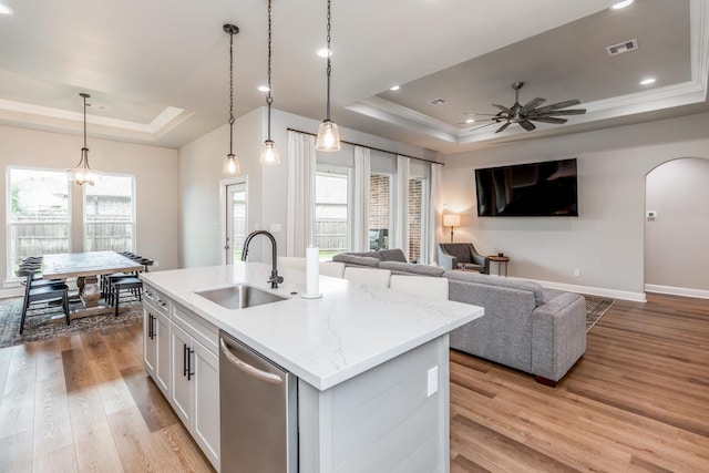 4813 Augusta Dr, Groves, TX 77619 - kitchen featuring a raised ceiling, stainless steel dishwasher, healthy amount of natural light, light wood-type flooring, and crown molding