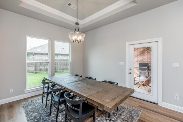 4813 Augusta Dr, Groves, TX 77619 - dining space with a raised ceiling, healthy amount of natural light, a chandelier, crown molding, and wood finished floors