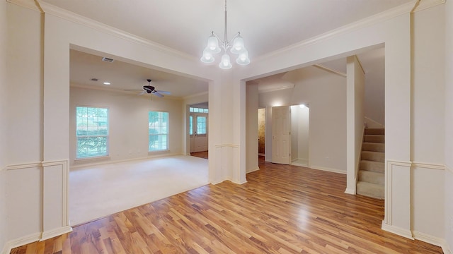 empty room with stairs, ornamental molding, baseboards, and light wood-style floors