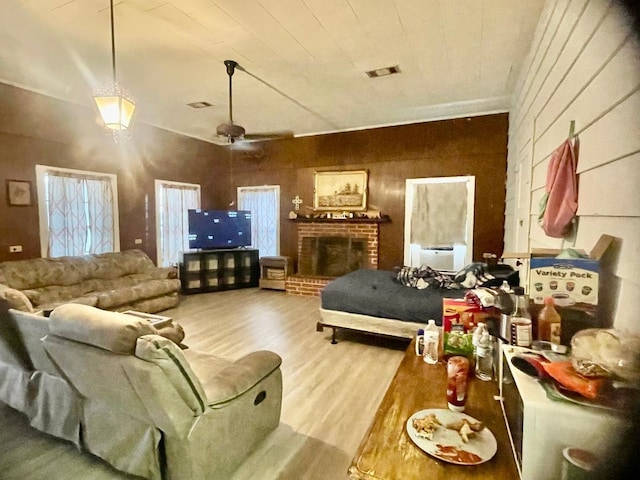 living room with a fireplace, wood-type flooring, and ceiling fan