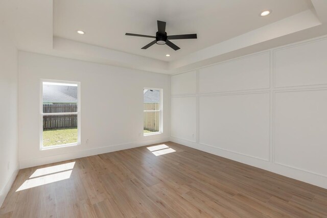 3580 Lily Ln, Beaumont, TX 77713 - empty room featuring a raised ceiling, light wood finished floors, ceiling fan, a decorative wall, and recessed lighting