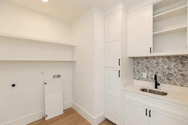 3580 Lily Ln, Beaumont, TX 77713 - washroom featuring cabinet space, electric dryer hookup, light wood finished floors, baseboards, and wet bar