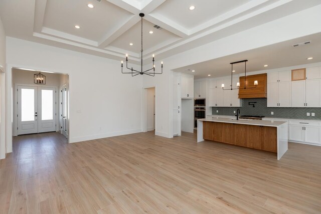 3580 Lily Ln, Beaumont, TX 77713 - kitchen featuring a chandelier, light countertops, coffered ceiling, decorative backsplash, and white cabinets