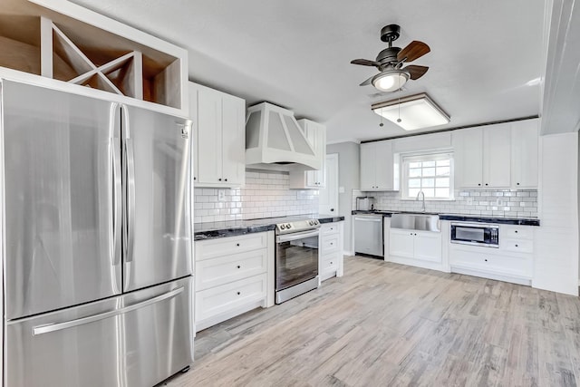 845 Flicker St, Bridge City, TX 77611 - kitchen featuring appliances with stainless steel finishes, premium range hood, dark countertops, and a ceiling fan