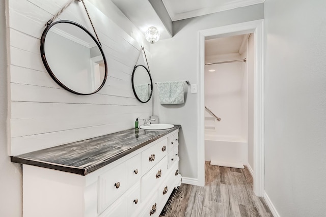 bathroom with  shower combination, vanity, hardwood / wood-style flooring, and crown molding