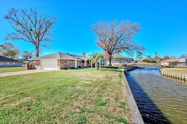 view of front of property with a garage, a water view, and a front yard