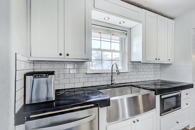 kitchen with backsplash, sink, white cabinetry, and built in microwave