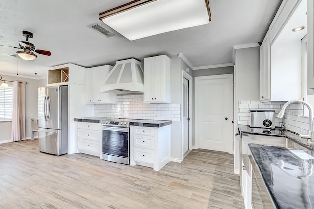 kitchen featuring appliances with stainless steel finishes, tasteful backsplash, custom range hood, ceiling fan, and white cabinetry