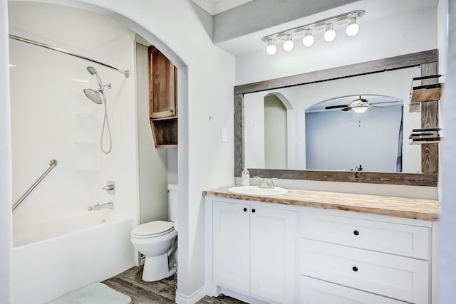 full bathroom featuring ceiling fan, toilet, vanity, bathtub / shower combination, and hardwood / wood-style flooring