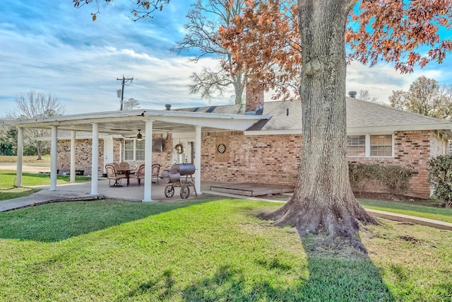 845 Flicker St, Bridge City, TX 77611 - rear view of property with a lawn, a chimney, a patio area, brick siding, and ceiling fan