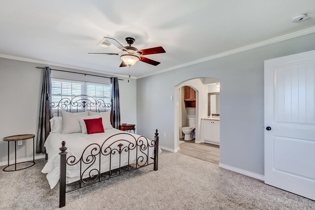 carpeted bedroom featuring connected bathroom, ceiling fan, and ornamental molding