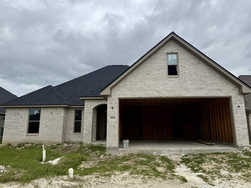 3860 W Pointe Dr, Beaumont, TX 77706 - view of front of home featuring brick siding and a shingled roof