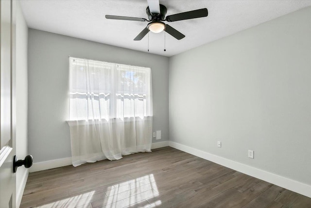 unfurnished room with a ceiling fan, baseboards, and wood finished floors