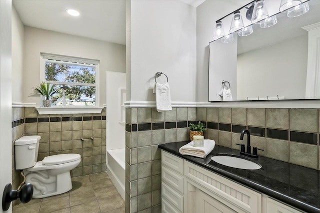 bathroom featuring vanity, tile walls, toilet, and tile patterned floors