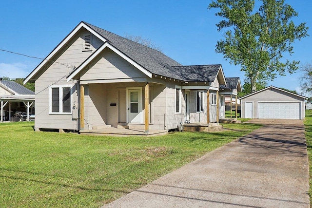 bungalow-style house with a detached garage, a front lawn, an outdoor structure, and a shingled roof