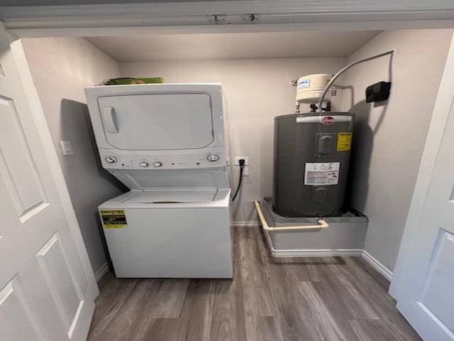 laundry room with hardwood / wood-style floors, electric water heater, and stacked washer / dryer