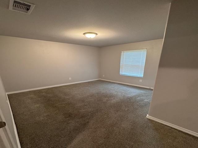 spare room with dark carpet