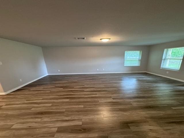 unfurnished room with dark hardwood / wood-style flooring