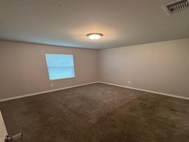 spare room with dark carpet