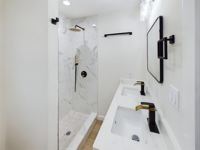 bathroom featuring tiled shower and vanity