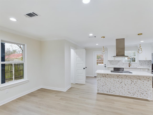 kitchen with white cabinetry, sink, decorative light fixtures, and island exhaust hood