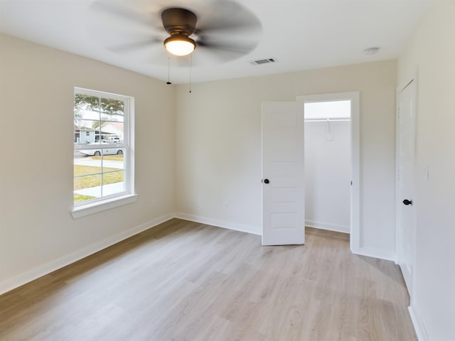 unfurnished bedroom with ceiling fan, light hardwood / wood-style floors, and a closet