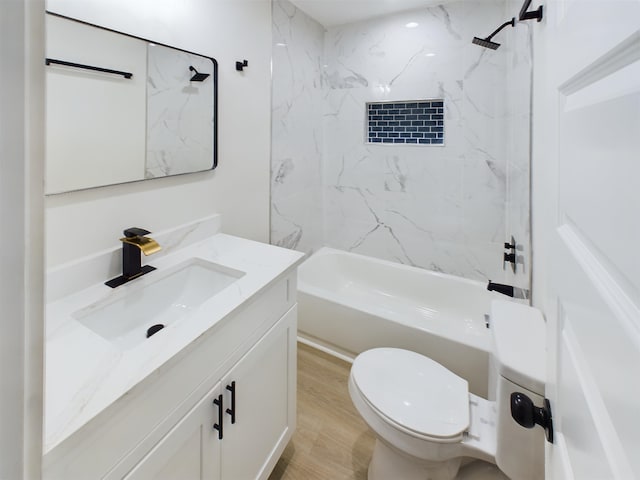 full bathroom with hardwood / wood-style flooring, tiled shower / bath, vanity, and toilet