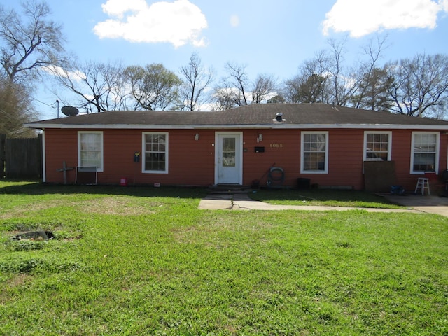 ranch-style house featuring fence and a front lawn