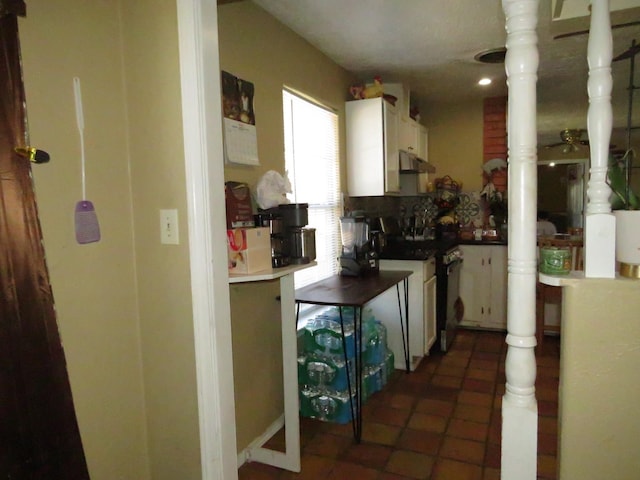 5055 Sunbury Dr, Beaumont, TX 77707 - kitchen with range, under cabinet range hood, white cabinets, tile patterned floors, and recessed lighting